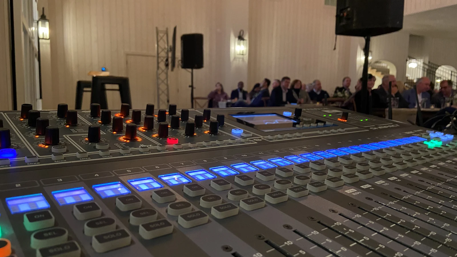 Digital mixing console at a corporate event in Utah with the audience and speakers in the background