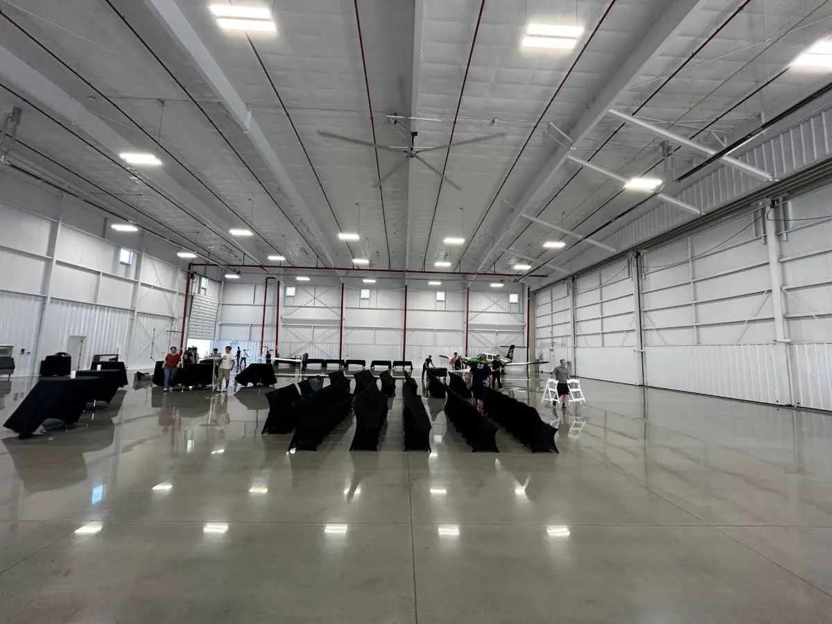 Empty airport hangar with stacked chairs before the event build