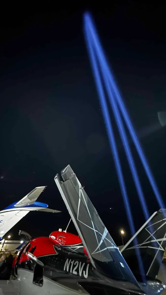 Blue beams rising above the tails of parked aircraft