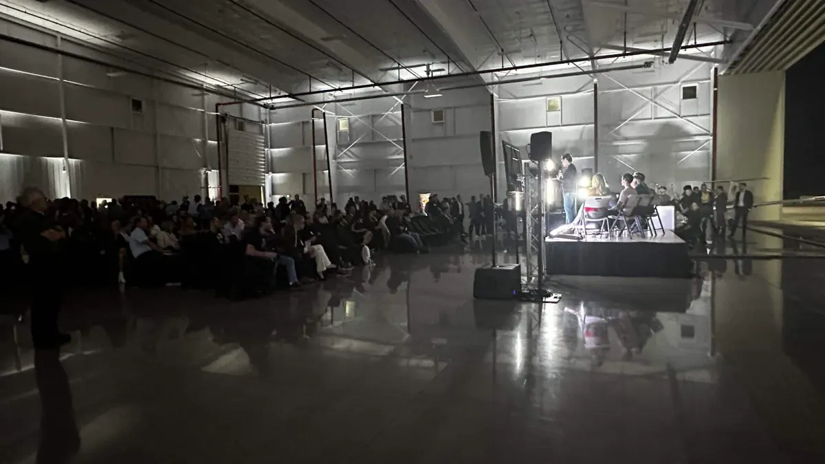 Crowd gathered near the stage at the far end of the hangar