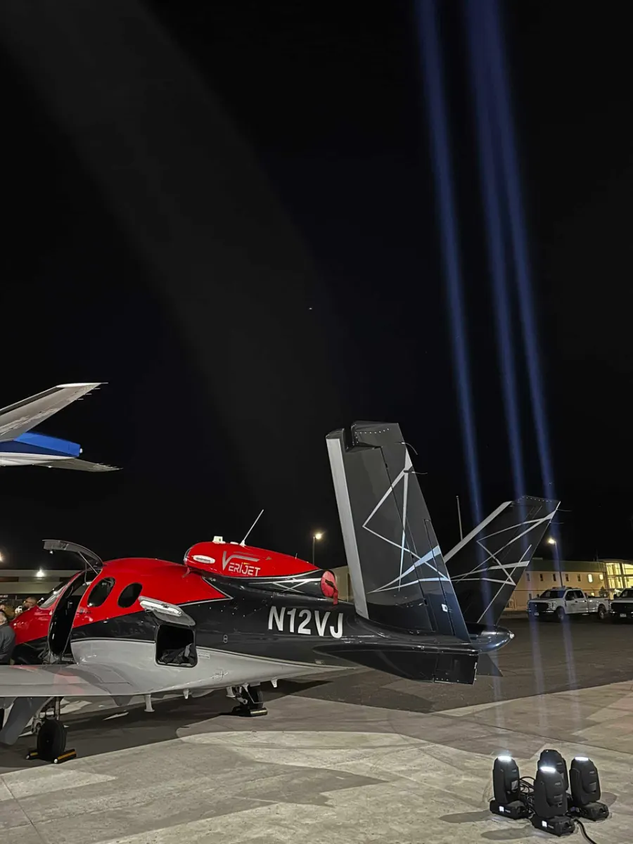 Moving head beams over a red aircraft on the hangar floor