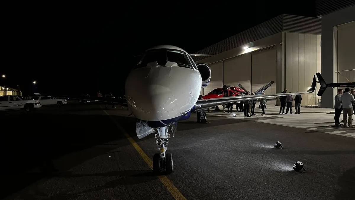 Private jet uplit on the ramp outside the hangar at night