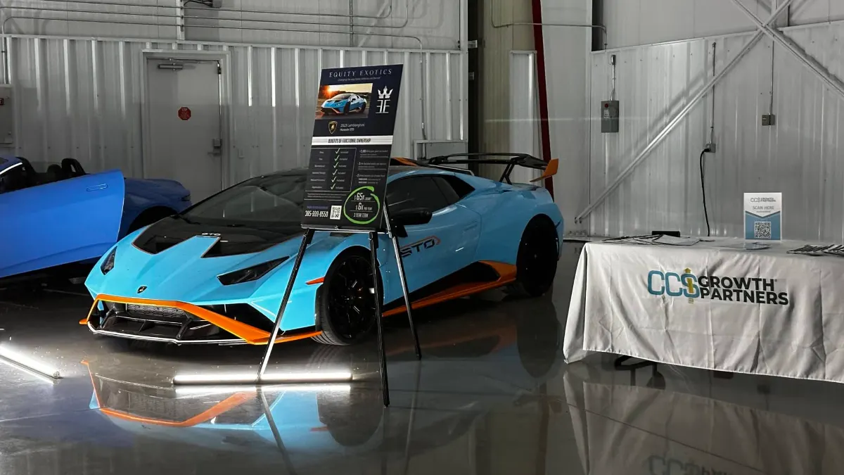 Blue and orange supercar lit by LED fixtures on the hangar floor