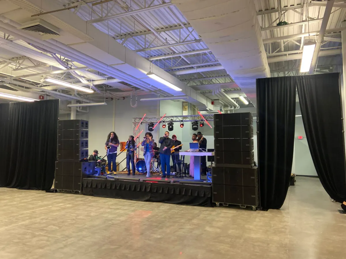 Live band performing on a staged ballroom setup with the sound system in place