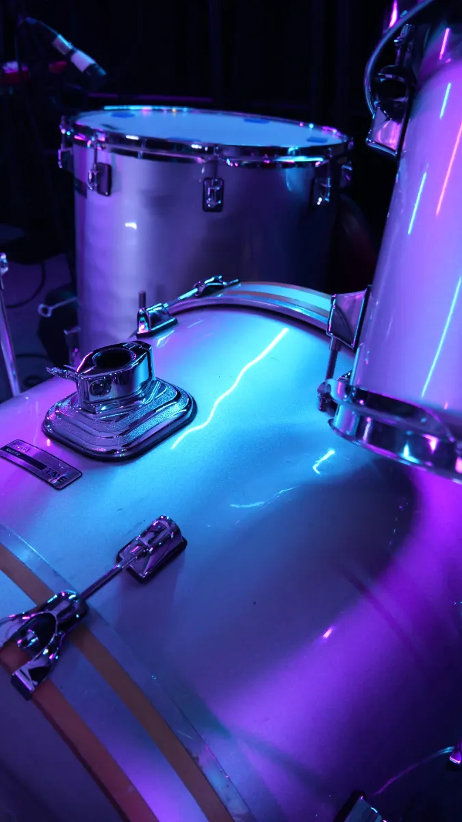 Drum kit miked and lit on stage before a live set