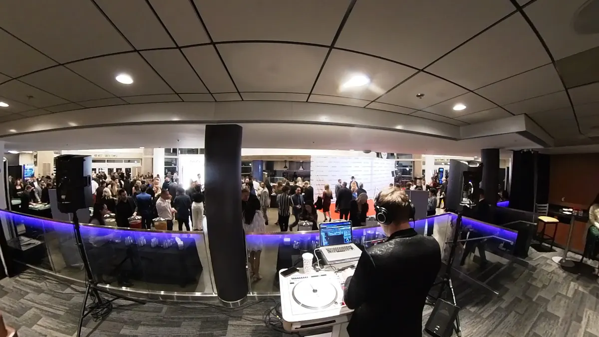 Front of house mix position at a conference with the room filling behind it