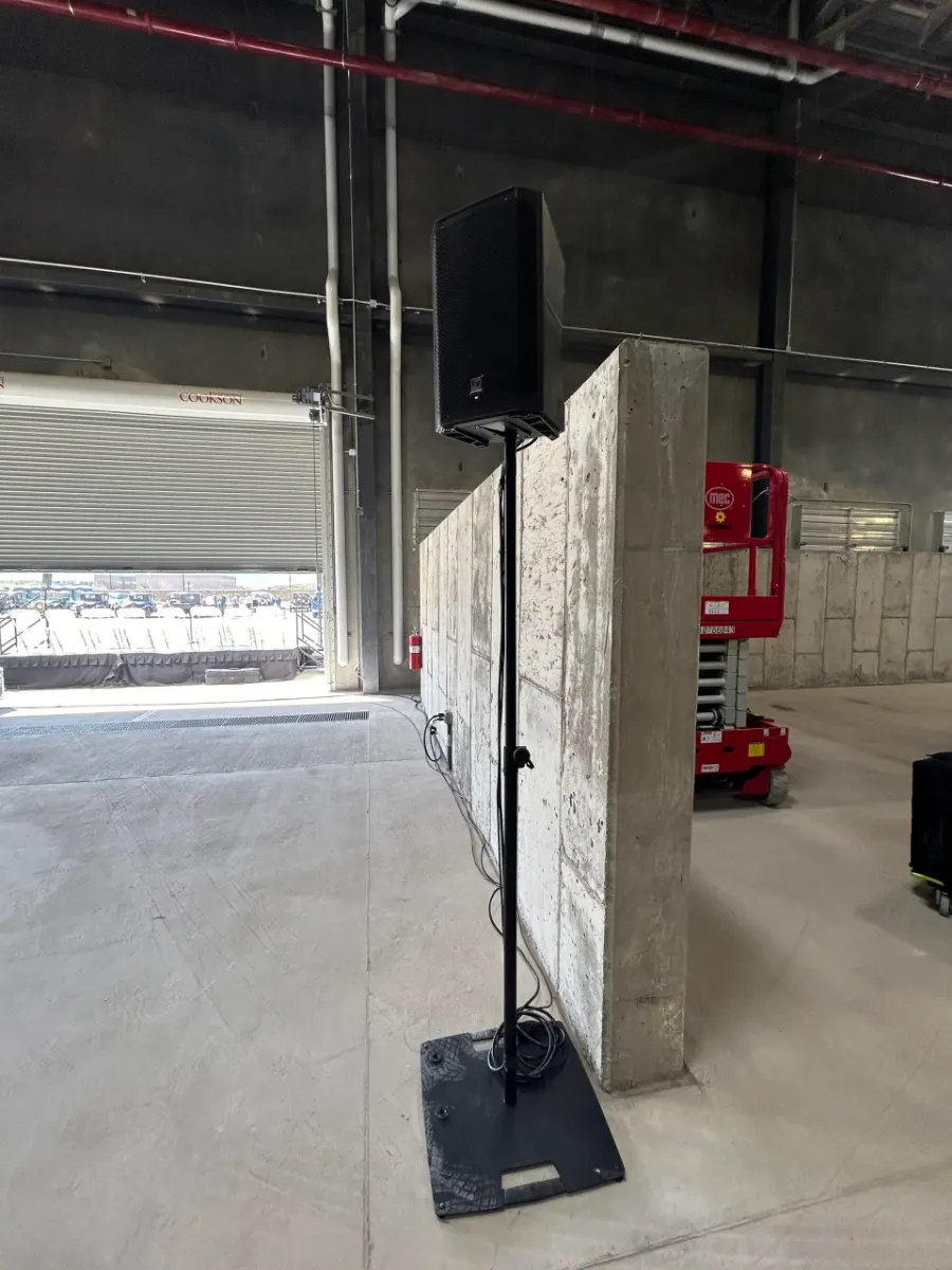 Powered speaker on a stand positioned in the building's open bay