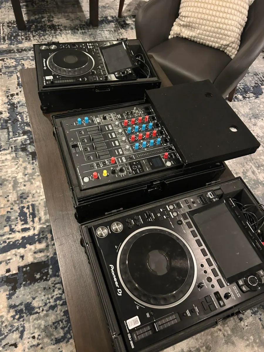 Two CDJ-3000 players either side of a DJM-900 NXS2 mixer set up on a table