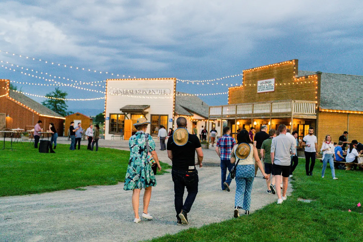 Guests walking the grounds at an outdoor SmallSat reception at West Heritage Farm