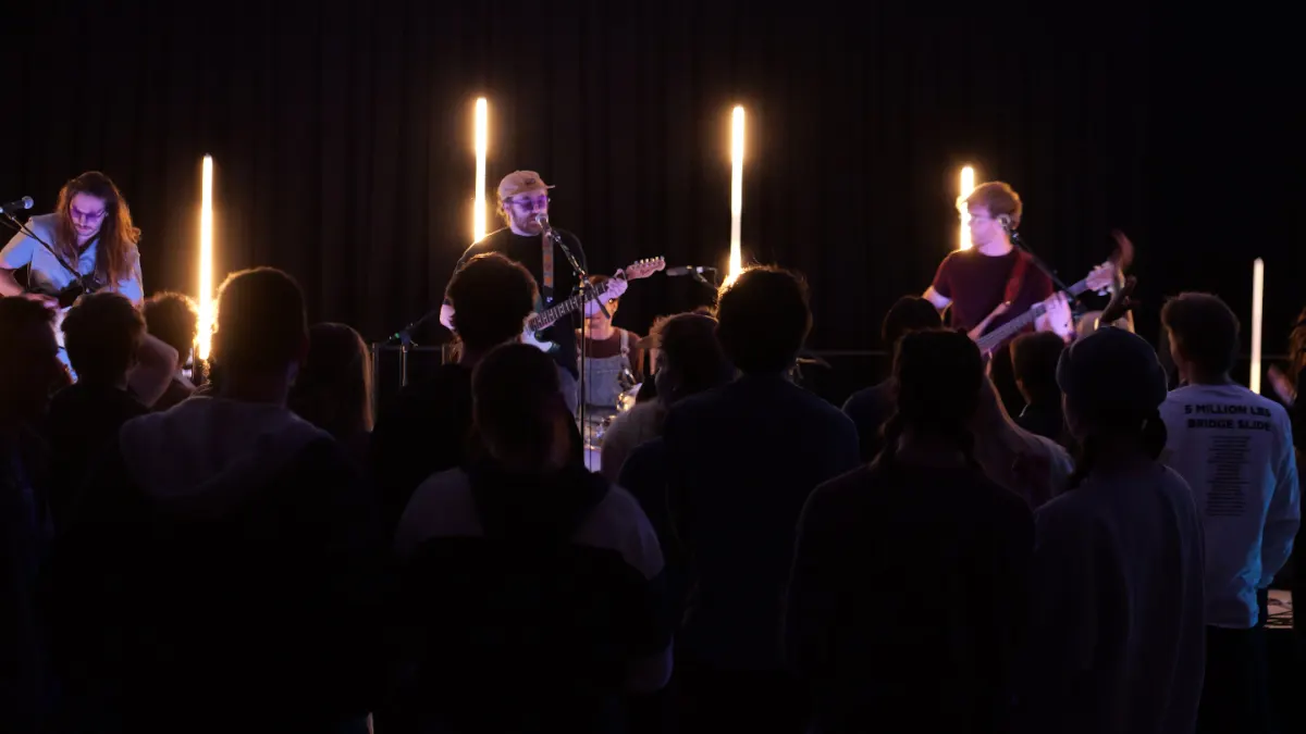 Band silhouetted against glow tubes during the late night set