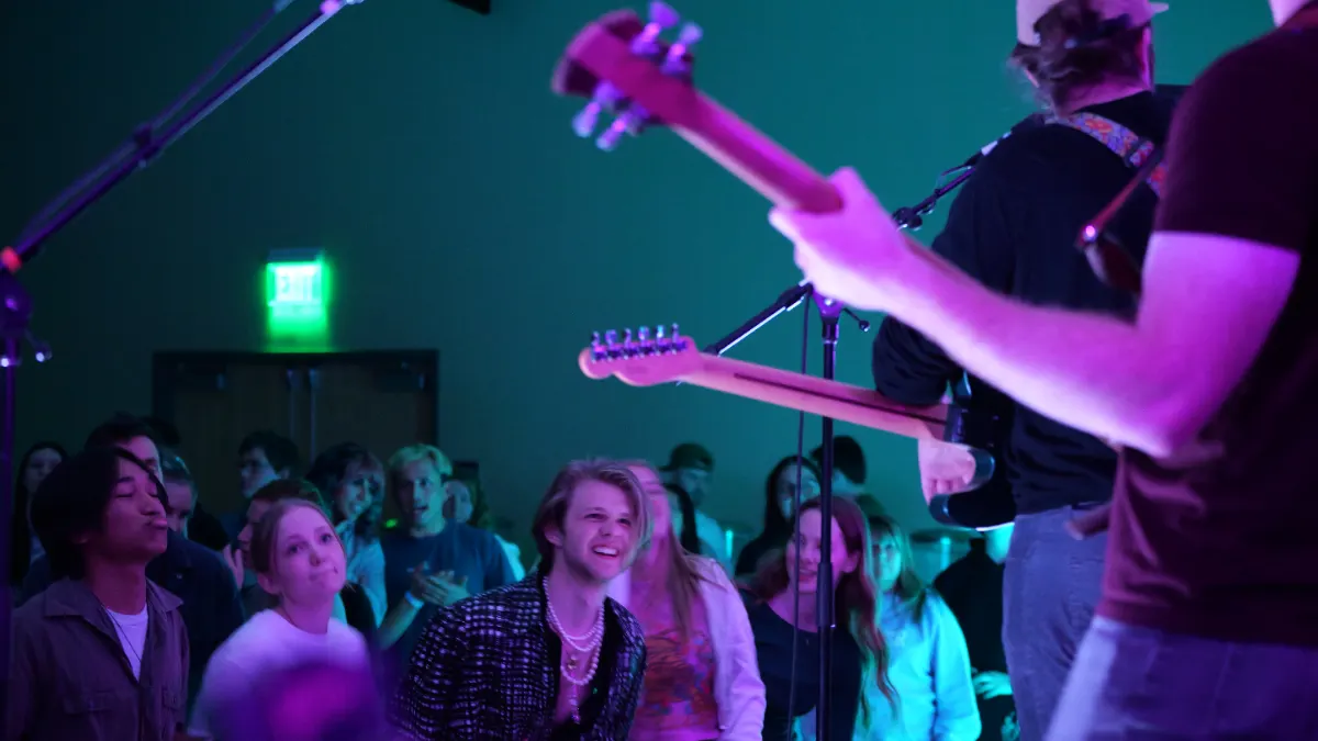 Bassist playing at the edge of the stage with the front row right there