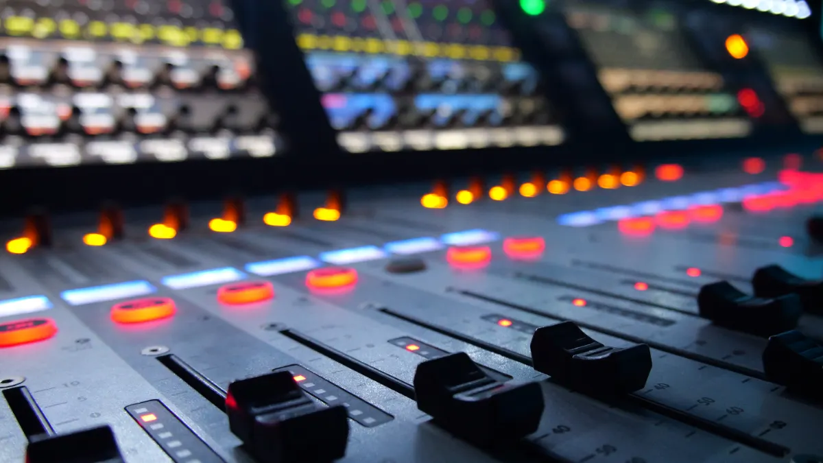 Front of house mixing console with channel faders lit