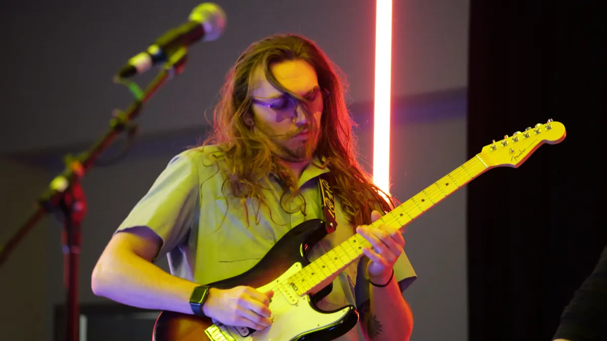 Lead guitarist performing under warm stage light