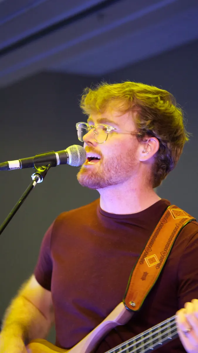 Singer at the microphone lit in warm amber