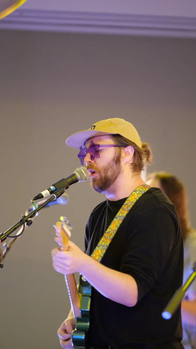 Vocalist singing into a microphone while playing guitar