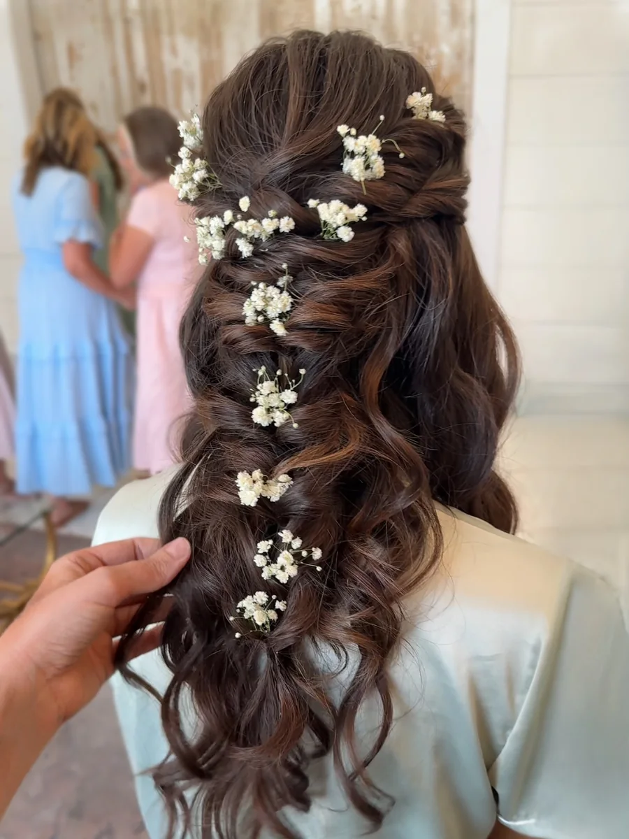 Heather Dear Artistry setting baby's breath into a half-up braid