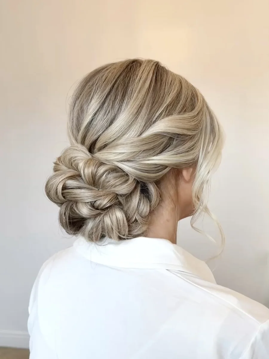 Blonde low twisted bun with loose face-framing pieces, by Heather Dear Artistry