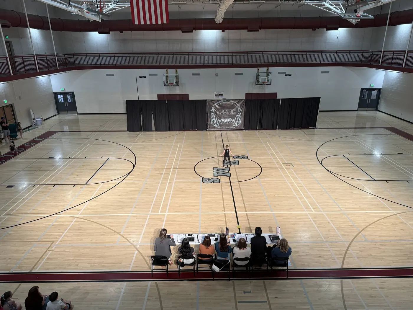 Overhead view of a school gym set for a dance competition with stage wash lighting