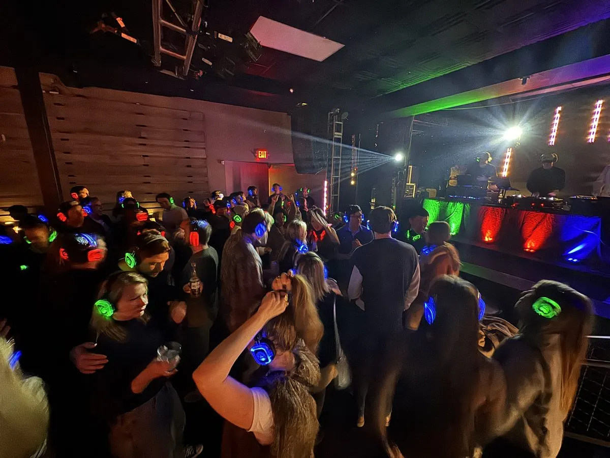 Crowd dancing at a Reeverb Entertainment silent disco with red, green, and blue LED headsets