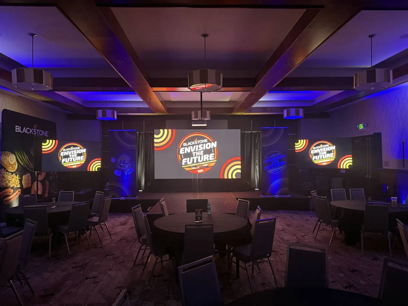 Hotel ballroom conference set with round tables and blue accent lighting